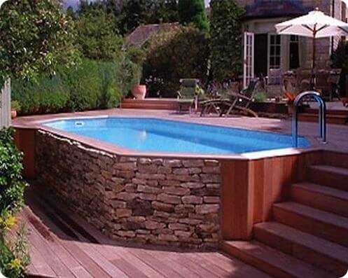 awesome above ground pool with wood and stone wraparound deck