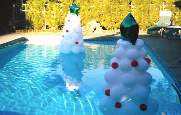 holiday trees made from balloons floating in a pool