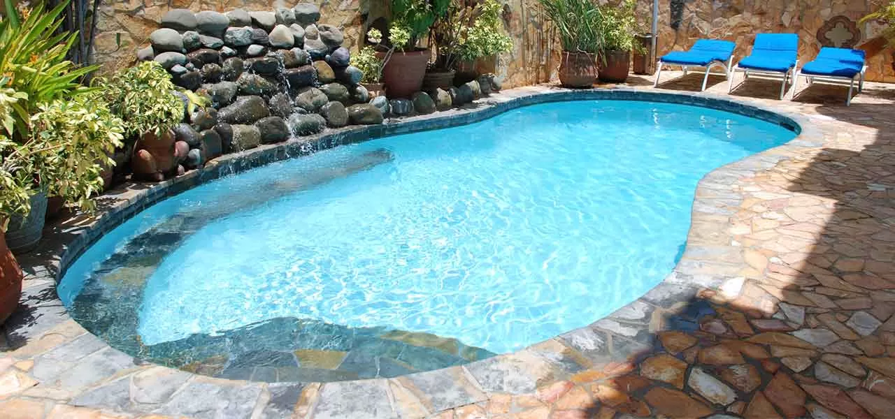 kidney shaped pool with stone waterfall